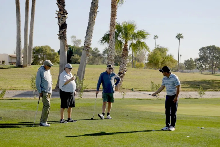 A golf coach provides one-on-one instruction to a player on a sunny course, demonstrating proper swing mechanics. The scene represents personalized, data-driven coaching that addresses mechanical, mental, and physical aspects of golf performance.